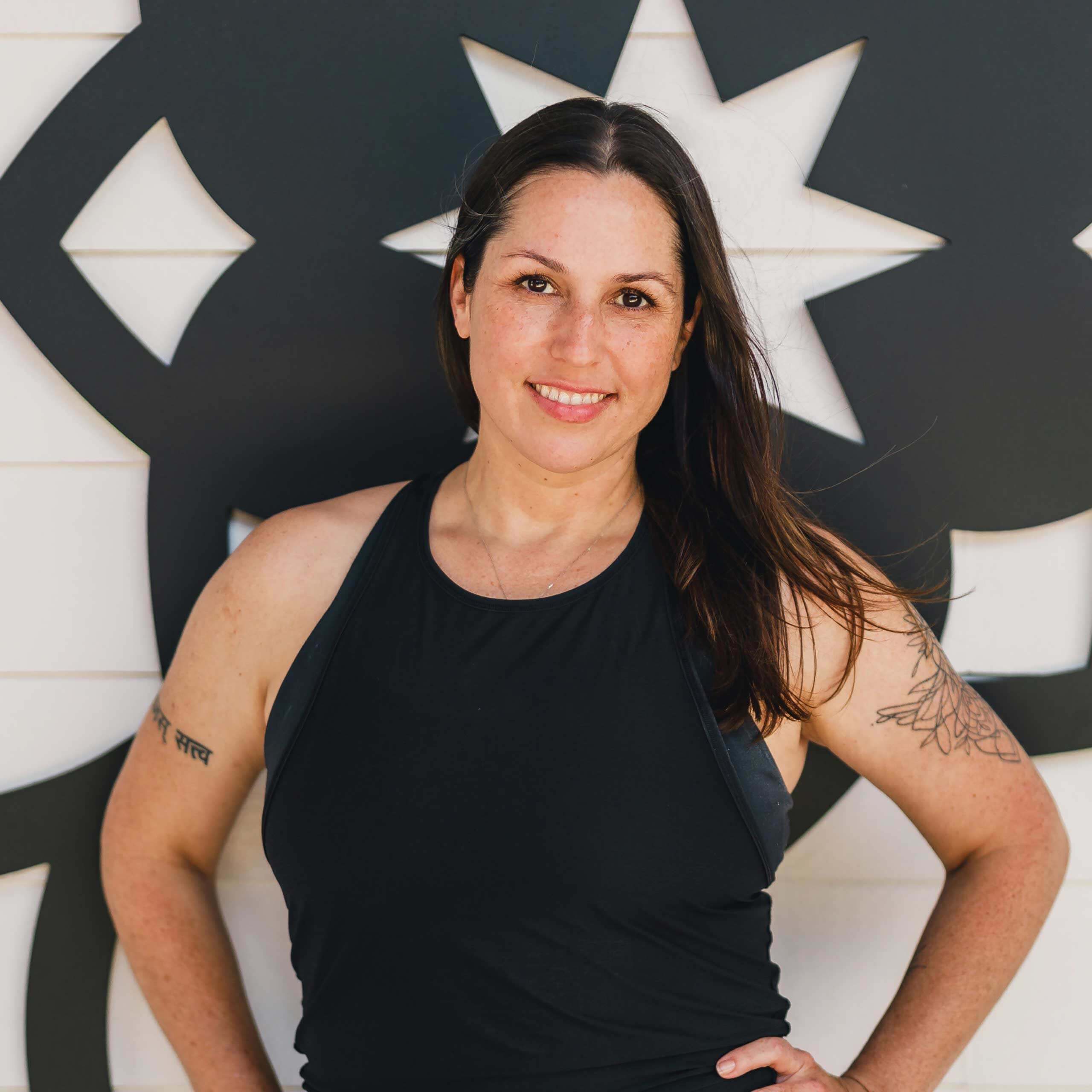 Michelle Young smiling in black top in front of the Mandala at My Vinyasa Practice in Austin Texas