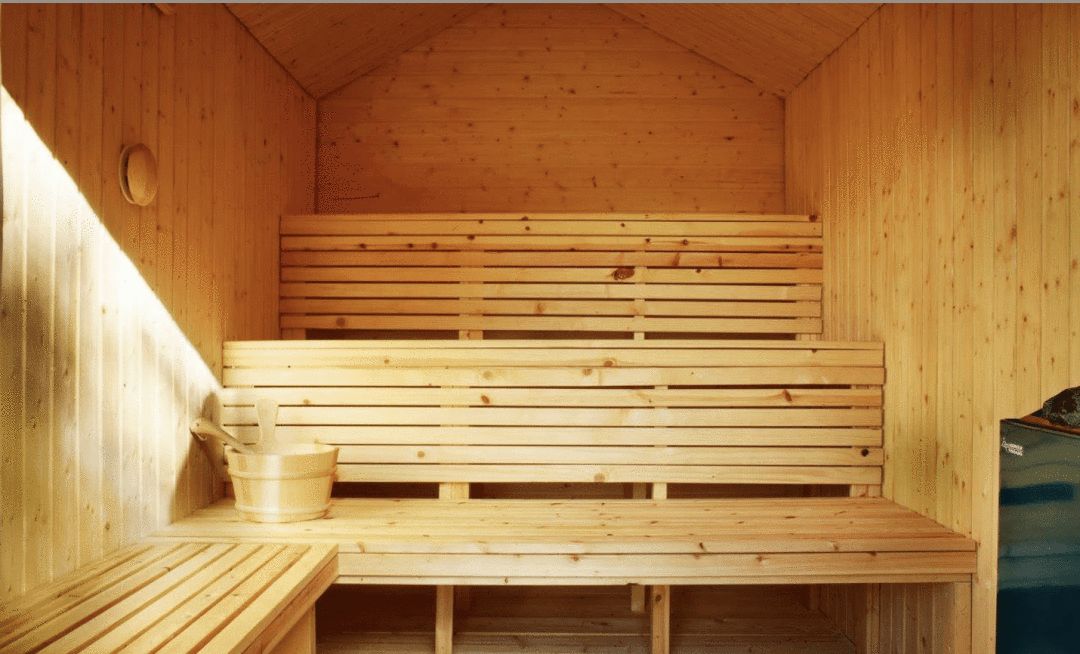 Image of a three-level sauna interior with wood water bucket