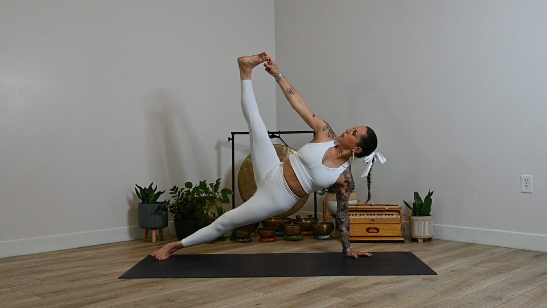 Woman in white ALO outfit in side plank variation 