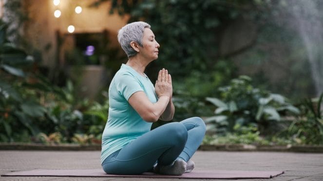 Woman sitting with hands at heart center meditating