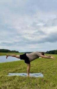 Student Alan Torres practices warrior 3 in a green park