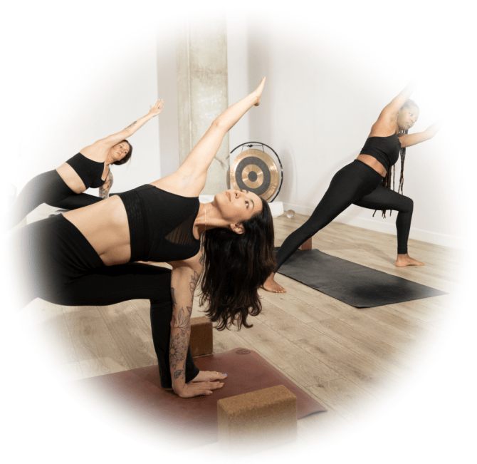 A yoga class of women yogis in reverse warrior pose.